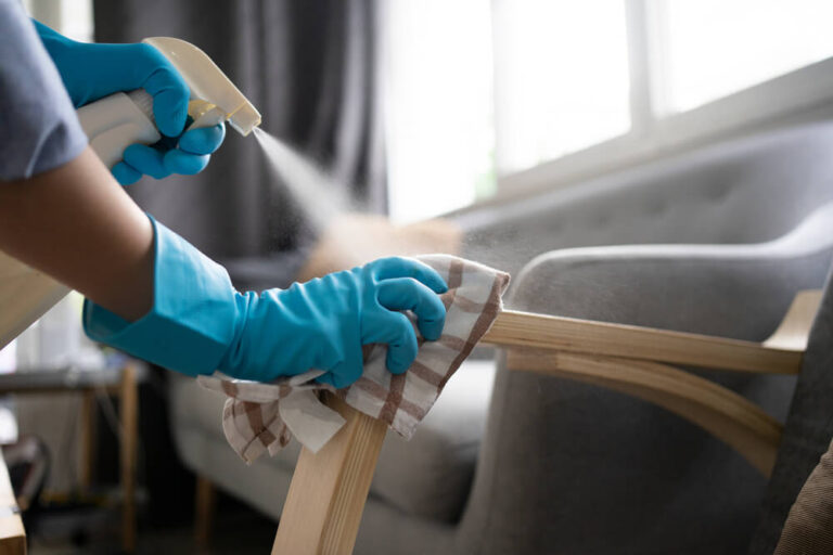 cleaning the arm of a chair in an apartment