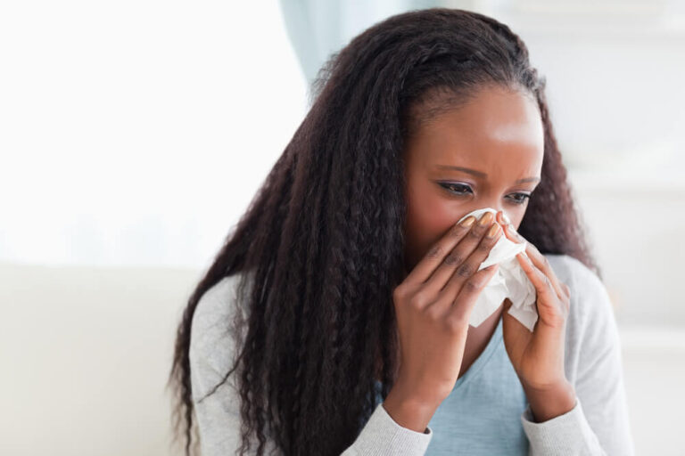 woman with tissue next to her nose with allergies