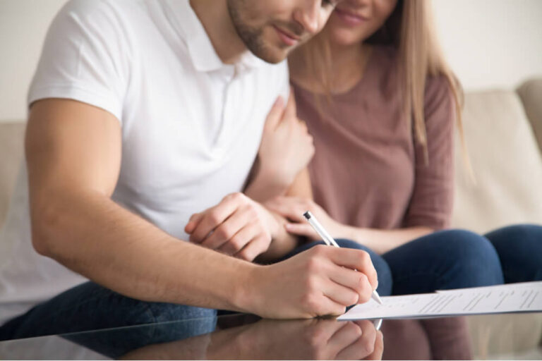 couple signing a lease on a new home rental