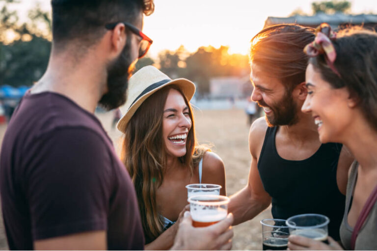 group of friends gather with drinks at a festival event